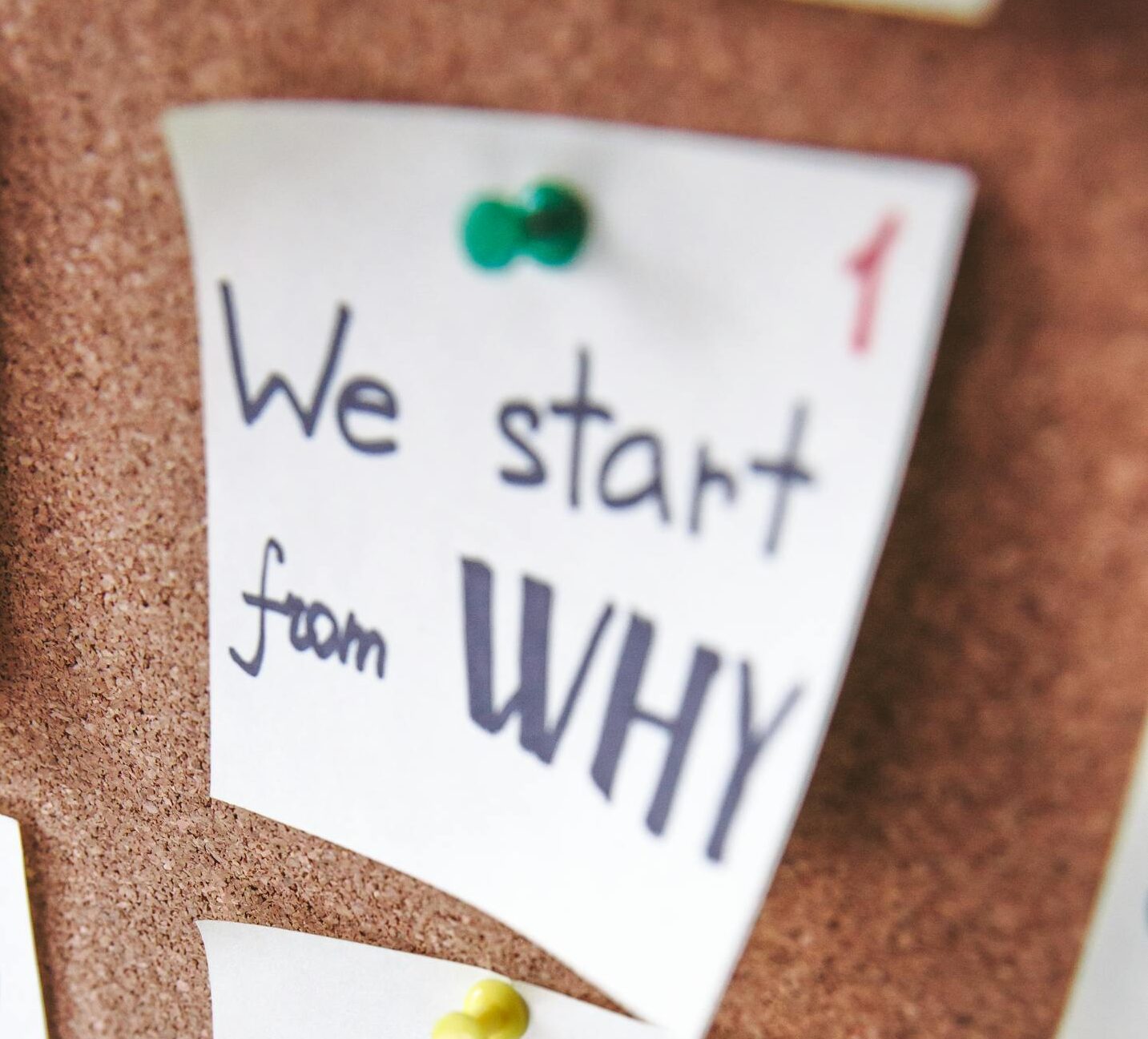 Close-up of motivational sticky notes with messages on a cork board.